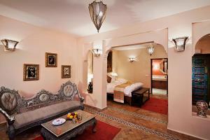 a living room with a couch and a bed at Kasbah Tamadot in Asni