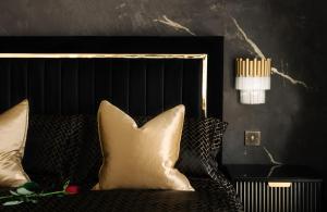 a bedroom with a bed with a black headboard and pillows at Casa Amor - Kinky Hotel UK in Southampton
