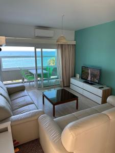 a living room with a white couch and a television at GARNET Beach Apartment in Oroklini