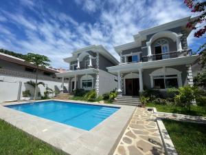 a house with a swimming pool in front of it at Linda's Little Lincoln in Watamu