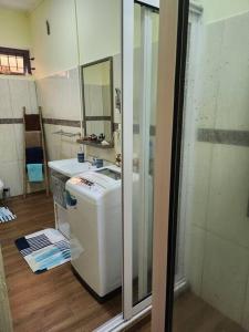 a small bathroom with a sink and a mirror at Kot Nu - Beach Themed Apartment - 3 mins walk from the sea in Flic-en-Flac