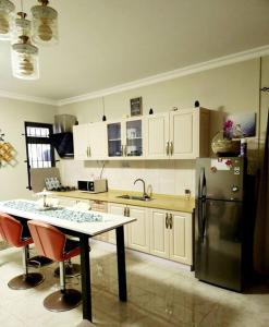 a kitchen with a refrigerator and a table with chairs at Kot Nu - Beach Themed Apartment - 3 mins walk from the sea in Flic-en-Flac
