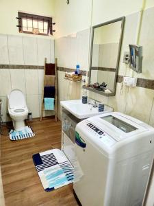 a bathroom with a sink and a toilet at Kot Nu - Beach Themed Apartment - 3 mins walk from the sea in Flic-en-Flac