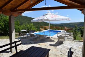 Stolac的住宿－Kamena Oaza，一个带桌子和遮阳伞的庭院和一个游泳池