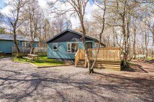 a tiny house in the middle of a yard at Gorse Lodge 9 with Hot Tub in Belladrum