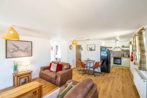 a living room with a couch and a table at Gorse Lodge 9 with Hot Tub in Belladrum