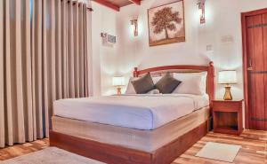 a bedroom with a bed with white sheets and pillows at Tepraas Sigiriya in Sigiriya