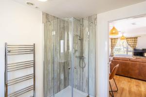 a shower with a glass door in a bathroom at Gorse Lodge 9 with Hot Tub in Belladrum +18 photos