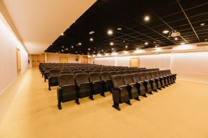 una habitación vacía con sillas negras en un teatro en Peñiscola Plaza Suites, en Peñíscola