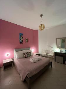 Colibri B&B في شاكا: غرفة نوم بسرير وجدار وردي