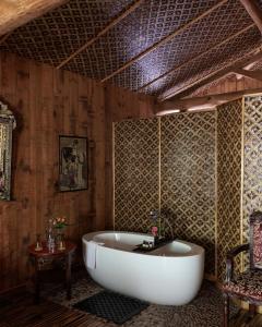 Cette chambre dispose de murs en bois et d'une baignoire. dans l'établissement Chateau Du Boisniard, à Chambretaud