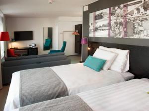 a bedroom with two beds and a living room at Original Sokos Hotel Koljonvirta in Iisalmi