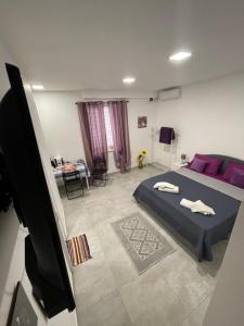 a bedroom with a bed with purple pillows at Tufaro B&B Private Room in Macerata Campania