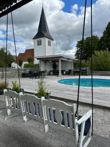 a swing in front of a church with a pool at Hangvar Skola, Bildsalen in Lärbro