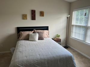 a bedroom with a large bed with pink pillows at Stylish, Cozy Corporate Townhome with Pool! in Greensboro