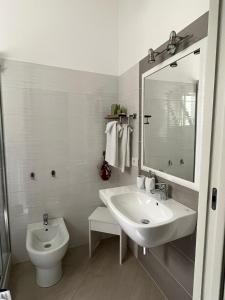 uma casa de banho branca com um lavatório e um WC em Colibri B&B em Sciacca