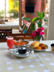 stół z dwoma talerzami jedzenia i drinka w obiekcie Riacho do Recanto Pousada w mieście Barreirinhas