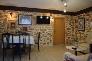 Stolac的住宿－Kamena Oaza，一间设有桌子和石墙的用餐室