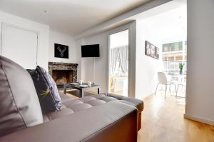 een woonkamer met een bank en een open haard bij Perfect apartment for beach lovers, next to the sailing club in El Arenal
