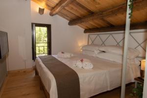 1 dormitorio con 1 cama con toallas en Villa Tatai Country House by Dimore Trinacria en Belvedere