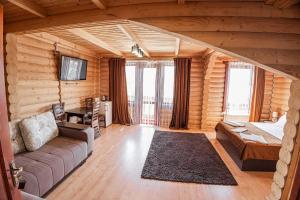 salon w drewnianym domku z kanapą w obiekcie Готель Чарда w mieście Bukowel