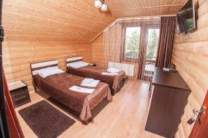a room with two beds and a television in a cabin at Готель Чарда in Bukovel