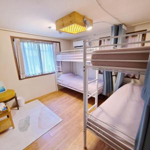 a room with two bunk beds and a window at Batwo Stay - For foreigners only in Seoul