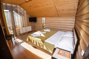 1 dormitorio con 1 cama en una habitación de madera en Готель Чарда, en Bukovel
