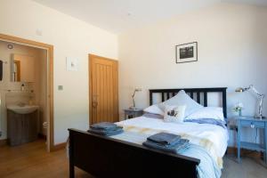 a bedroom with a bed with towels on it at The Tack Room - rural boutique retreat for two in Clapham