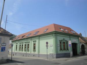 zielony budynek z brązowym dachem na ulicy w obiekcie Guest house Ringhofer Vendégház w mieście Sopron