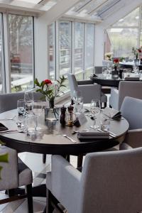 a dining room with tables and chairs with wine glasses at Brakanes Hotel in Ulvik