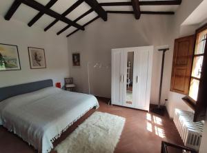 1 dormitorio con cama blanca y alfombra blanca en La Capanna, en Marradi