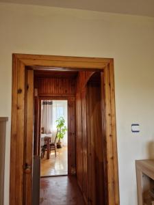 a wooden door leading into a room with a table at APARTAMENT zielona Retkinia - blisko ZOO, Atlas Arena, Mandoria, S14, Lotnisko in Łódź