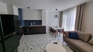 ein Wohnzimmer und eine Küche mit einem Sofa und einem Tisch in der Unterkunft Delta House - Beta apartment in Zadar