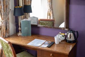 een bureau in een kamer met een spiegel en een tafel met bij Antelope by Greene King Inns in Poole