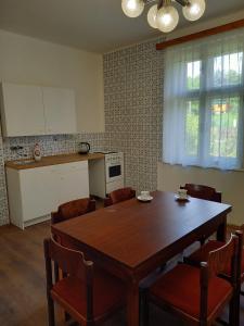 eine Küche mit einem Holztisch und Stühlen sowie eine Küche mit einem Tisch in der Unterkunft Vila Kotlářská in Děčín