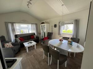 a living room with a table and a couch at Zandput 490 - Camping de Zandput in Vrouwenpolder