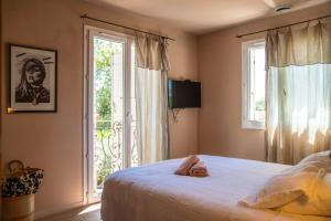 una camera da letto con un letto e una grande finestra di Villa Aprile a Saint-Étienne-du-Grès Altre 17 foto