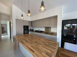 una cucina con ripiano in legno in una camera di LUTZY Maison moderne au calme piscine a La Teste-de-Buch