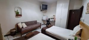una pequeña sala de estar con sofá y cama en Fouriestreet 199 Bed and Breakfast en Mokopane