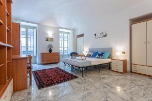 una camera con un letto in una stanza con finestre di Carlo Alberto House by Wonderful Italy a Torino