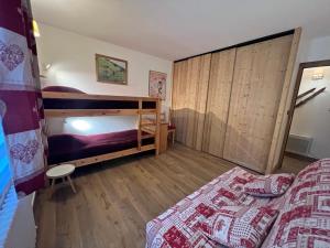 - une chambre avec 2 lits superposés et un mur en bois dans l'établissement Rose de Noel 145 - Proche pistes de ski, au calme, à La Clusaz
