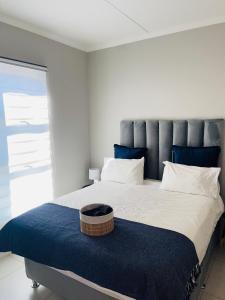 a bedroom with a large bed with a blue headboard at Dubai 2 in Midrand