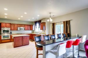 a kitchen with a large island with red chairs at Spacious Vacation Rental Near Utah Lake! in Lehi