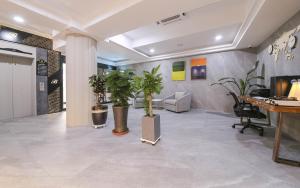 an office lobby with potted plants and a desk at Browndot Hotel Gwangju Pungam in Gwangju