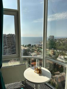 een kamer met een witte tafel en grote ramen bij Arkadia apartment with sea view in Odessa