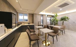 a restaurant with tables and chairs and a kitchen at Browndot Hotel Gwangju Pungam in Gwangju