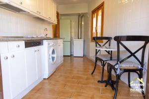 cocina con lavadora, mesa y sillas en Mirador Palacios- céntrico con vistas en Albarracín