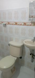 a bathroom with a white toilet and a sink at Encantadora casa con ambiente guajiro #3 in Barranquilla
