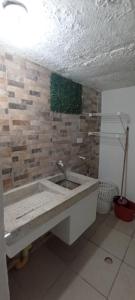a bathroom with a sink and a stone wall at Encantadora casa con ambiente guajiro #3 in Barranquilla
